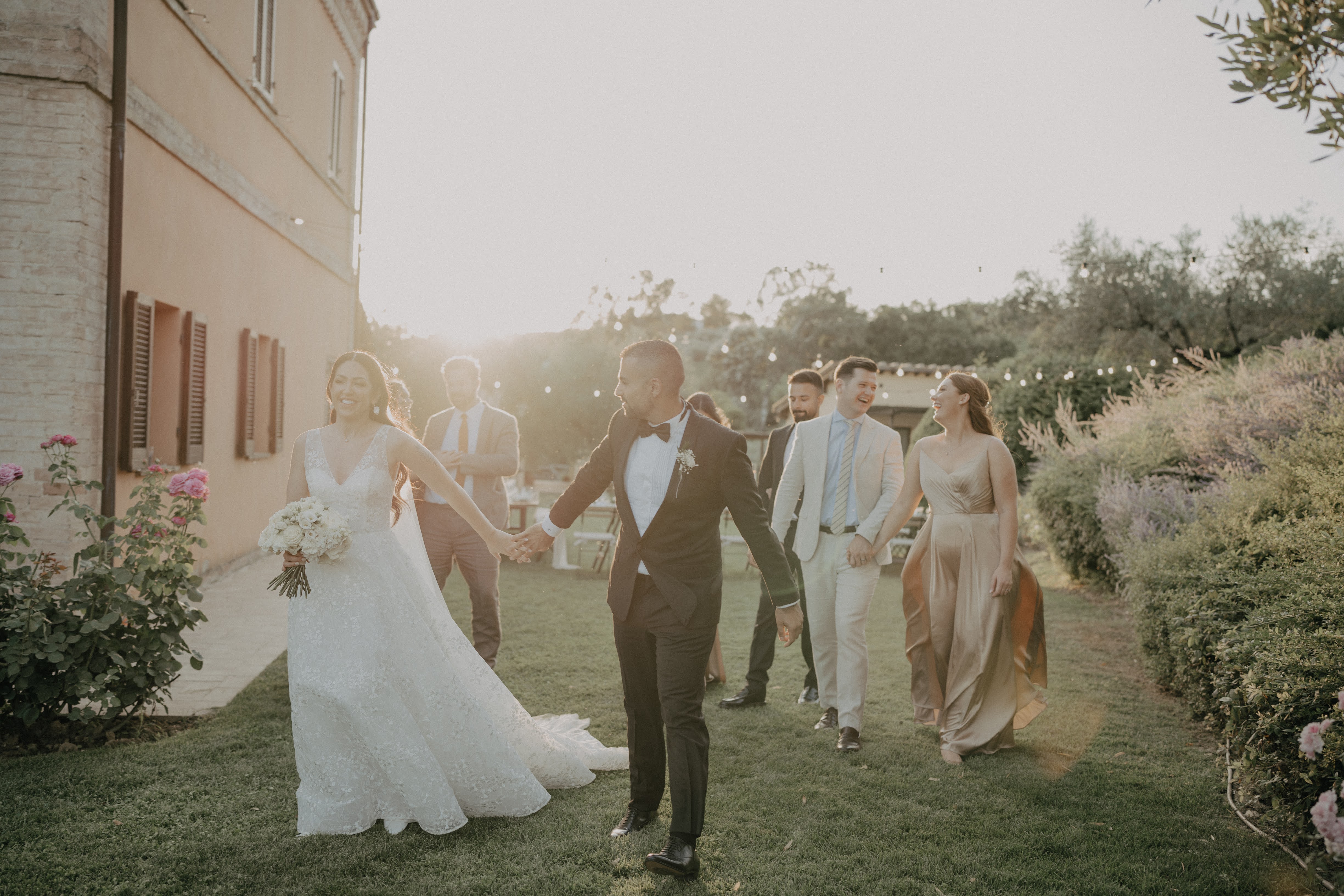 Couple et invités marchant au coucher du soleil